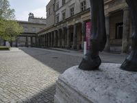 there is a horse statue next to some buildings and cobblestones in the street