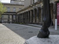 there is a horse statue next to some buildings and cobblestones in the street