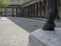 there is a horse statue next to some buildings and cobblestones in the street