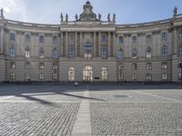 a large building is surrounded by buildings with many windows and windows all around it the building has two clock towers