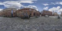 this is a spherical 360 - vr image taken on a cobblestone surface looking like it is in an urban area