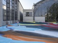 some colorful paint on the ground and buildings in the background is painted with colored lines