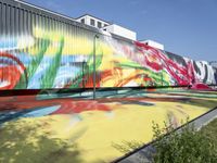 there are several different colors on this building side wall in color, with large colorful graffiti