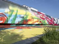 there are several different colors on this building side wall in color, with large colorful graffiti