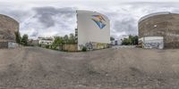 a fisheye photograph of a concrete building, with some graffiti on it's walls