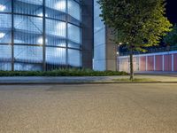 a white van parked by a sidewalk in front of a building in the city at night