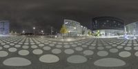 a spherical photograph of city and buildings in the background is a night sky with stars