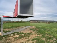 an upside down building in a grassy field on top of a hill with some grass