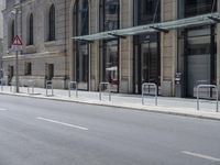 empty street with two signs in front of tall buildings in urban area with no people