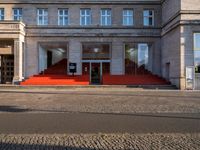 there is a red and white building and stairs outside it that says public security, with an empty street