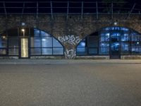 the entrance to an empty building with graffiti written on it and light in the window