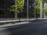 the road is empty near some buildings and trees that are lined with metal barriers on both sides