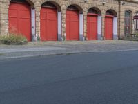 there is a red fire engine in the background of an old building with five red doors