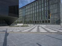 a shadow of a person is seen on the ground in front of a building with geometric patterns
