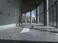 a wide walkway with metal grates going through it and a sky background looking over a city