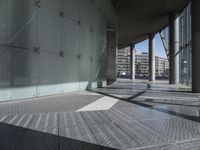 a wide walkway with metal grates going through it and a sky background looking over a city