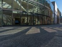 Berlin, Germany: Glass Wall on Cobblestone