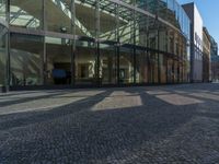 Berlin, Germany: Glass Wall on Cobblestone