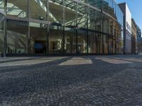 Berlin, Germany: Glass Wall on Cobblestone