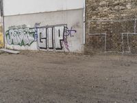 a graffiti covered white building with graffiti in the corner and a red fire hydrant