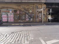 there is an overhead view of a graffiti covered building on a street corner, with car parking spaces in front of it