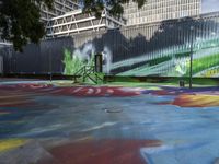 a kid rides a skateboard across a colorful field of paint in front of a building