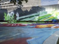 a kid rides a skateboard across a colorful field of paint in front of a building