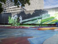 a kid rides a skateboard across a colorful field of paint in front of a building