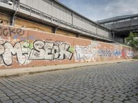 a building with a very nice graffiti on it is next to a wall with various letters