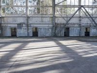 the view of a empty room with large windows and walls, with a few dogs, in it