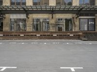 an empty building with signs on the street and people on bikes in traffic passing by