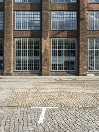 red brick street with two windows and a white arrow marking the center on the right hand side