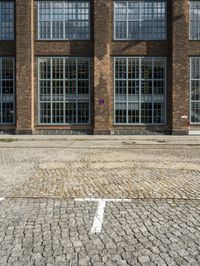 red brick street with two windows and a white arrow marking the center on the right hand side