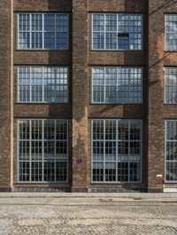 red brick street with two windows and a white arrow marking the center on the right hand side