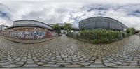 two circular views of a building with graffiti in front of it, with the view from the side