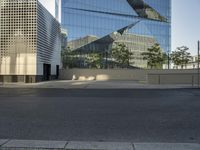 the reflection in the glass of a building across from a road that is being blocked off by fencing