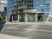 this is the entrance to a modern office building near a street corner, showing the round stone facade