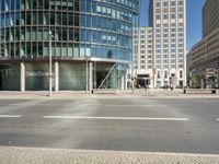 this is the entrance to a modern office building near a street corner, showing the round stone facade