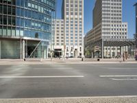 the street corner is empty with very tall buildings in the background at a street corner