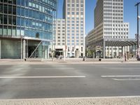 the street corner is empty with very tall buildings in the background at a street corner