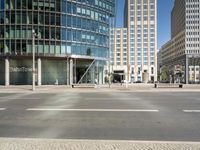 the street corner is empty with very tall buildings in the background at a street corner