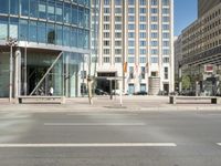 the street corner is empty with very tall buildings in the background at a street corner