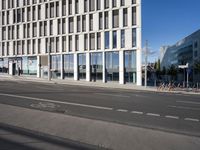 a city street has a large building and bicycles parked in front of it on the side
