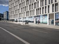 a city street has a large building and bicycles parked in front of it on the side