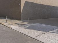 a brick wall with two street meters attached to it on a sidewalk in front of a brick building