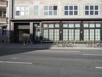 a city intersection with a bike rack in front of it's entrance and some windows behind it