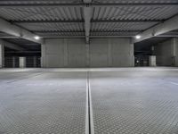 an empty parking garage with a sign indicating to wait for the next step down stairs