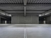 an empty parking garage with a sign indicating to wait for the next step down stairs