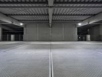 an empty parking garage with a sign indicating to wait for the next step down stairs