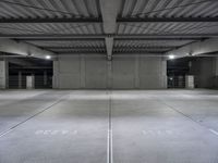 an empty parking garage with a sign indicating to wait for the next step down stairs